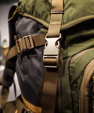 Detailaufnahme eines robusten Wanderrucksacks mit Gurten und Metallverschluss in einer Ausrüstungsausstellung